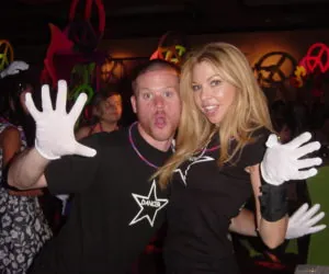 A man and a woman hamming it up for the camera in big white gloves.