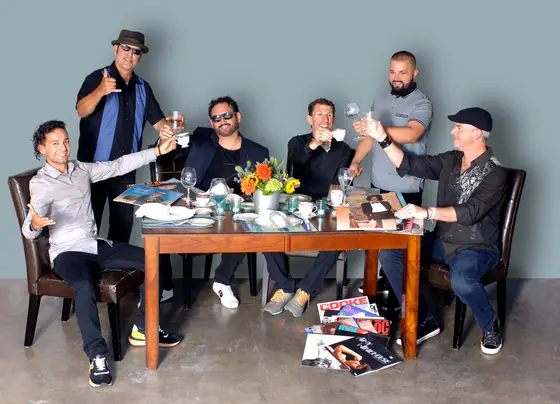 The Tasty Sounds DJs posing around a dinner table set with vinyl records instead of food.