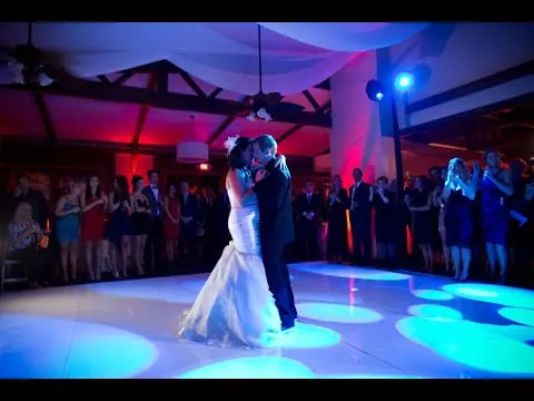 A first dance on a floor lit with blue and violet light.